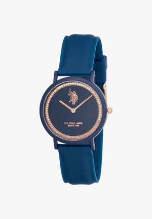 Montre bracelet bleu marine avec aiguilles dorées, lunette ornée de cristaux, logo U.S. Polo Assn. et bracelet en silicone.