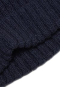 Donker marineblauw geribbelde tricotstof met een zachte, gestructureerde oppervlakte; toont een gevouwen rand, die de dikte en warmte van het materiaal benadrukt.