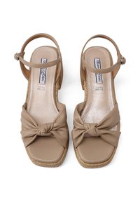 Sandali con zeppa in pelle beige, con dettaglio anteriore annodato, punta quadrata e cinturino alla caviglia. Suola in stile espadrillas con texture.