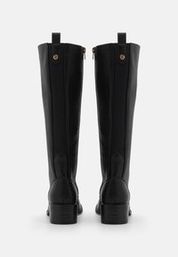 Svarta läderknähöga stövlar med en slät finish, bakdragkedjor, elastiska sidofickor och en låg klack. Utsmyckade med cirkulära knappar.