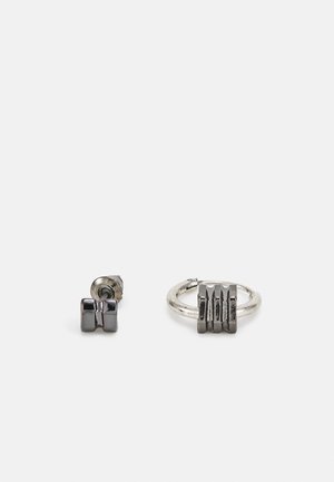 Brincos com um pequeno pino em forma de haltere texturizado em metal escuro e um argola maior com um detalhe correspondente de haltere.