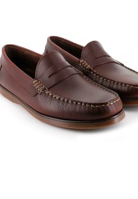 Los mocasines de cuero marrón presentan un diseño elegante con costuras visibles y una textura suave. La suela es de un color marrón claro que contrasta.