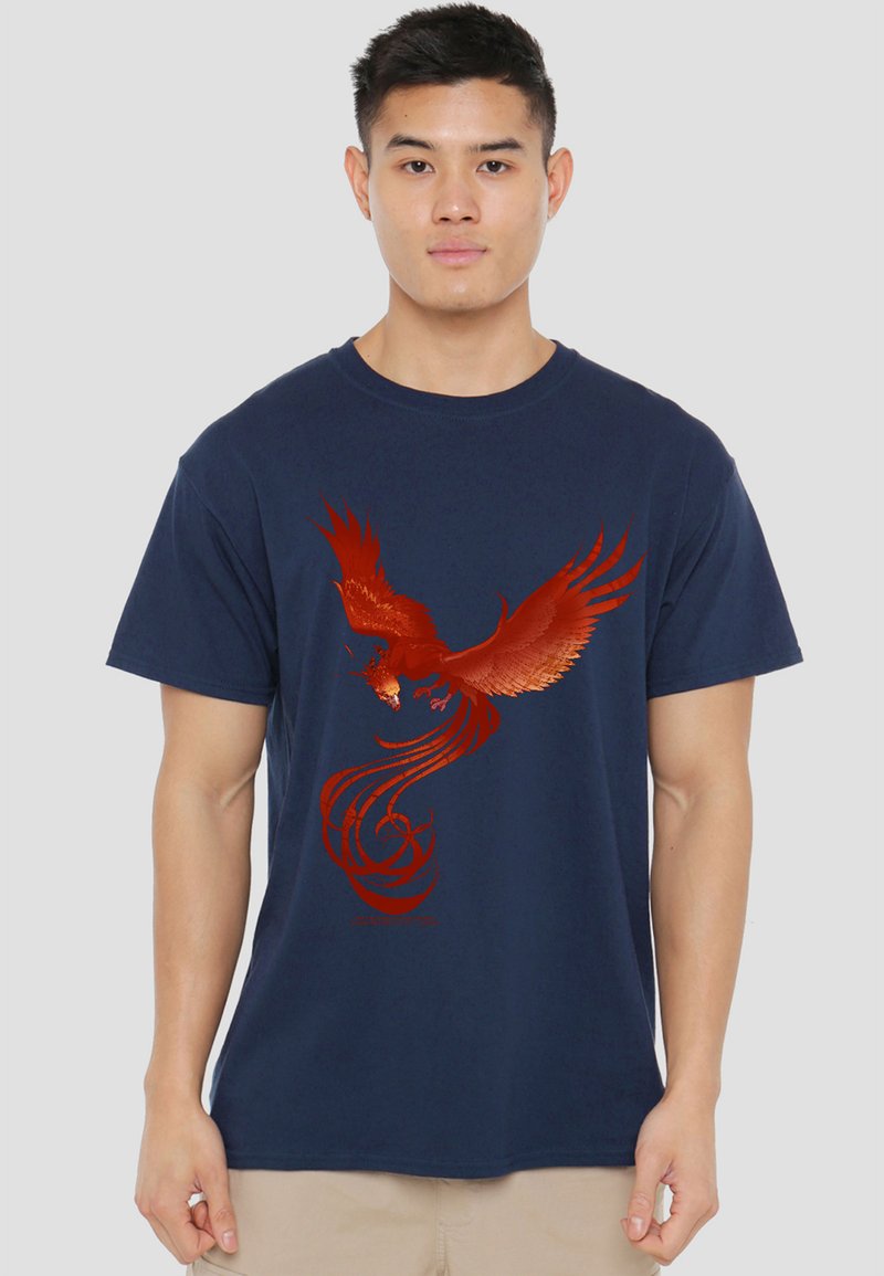 Young man wearing a navy blue T-shirt with a large red phoenix graphic spreading its wings on the front.