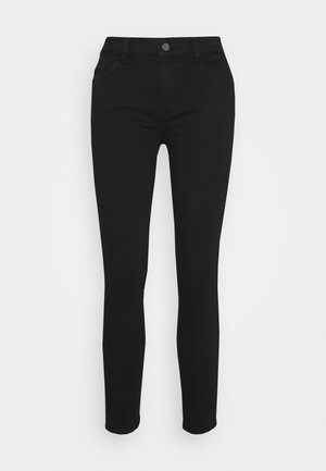 Musta slim fit -housut, joissa etunappi, vyölenkit ja etutaskut, esitettynä yksinkertaisen vaalean taustan edessä.