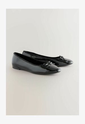 Black patent leather ballet flats with a pointed toe and small bow accent on the front, featuring a low, flat sole and smooth texture.