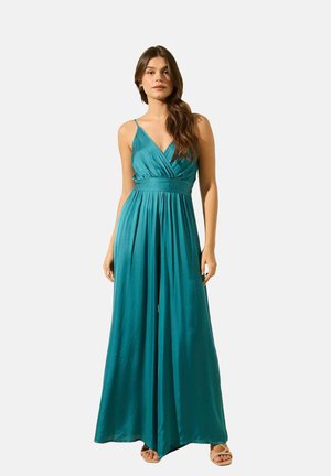Robe maxi teal en tissu léger et lisse avec un décolleté en V profond, des fines bretelles et une taille cintrée, silhouette fluide avec un drapé subtil.