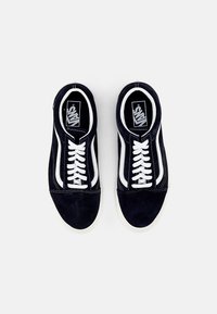 Baskets en nubuck bleu marine avec des lacets blancs, des bandes latérales blanches et une semelle en caoutchouc blanc contrastante. Texture lisse, design classique à profil bas.