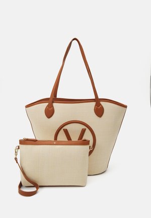 Beige woven tote bag with brown leather straps and circular logo, accompanied by a small, matching zipper pouch with a wrist strap.