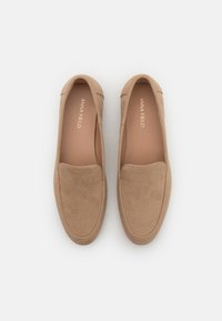 Béžové semišové mokasíny s kulatou špičkou, minimálním švem a hladkým vnitřním designem. Bez viditelného kovového příslušenství nebo vzorů.
