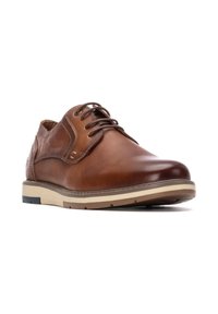Zapatos de cuero marrón con cordones, con un acabado suave, punta redonda y una suela de goma contrastante que presenta acentos claros y oscuros.