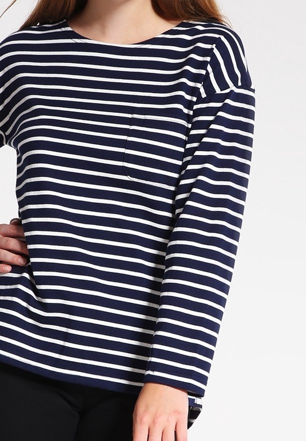 Navy och vita randiga långärmade skjorta med rund halsringning och en liten bröstficka. Tillverkad av mjukt material och har en avslappnad passform.