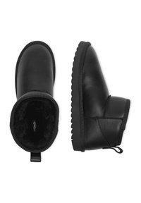 Melnas ādas potītes zābaki ar pūkainu iekšpusi, noapaļotu purngalu un teksturētu gumijas zoli. Iekļauts cilpiņas elements, kas atvieglo uzvilkšanu.