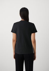 Sort bomulds T-shirt med korte ærmer og rund hals. Glat tekstur, enkelt design, ingen synlige mønstre eller udsmykninger.