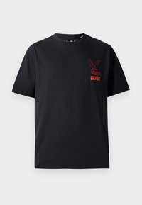 Schwarzes Baumwoll-T-Shirt mit kurzen Ärmeln, Rundhalsausschnitt und einem roten Grafiklogo eines Kaninchens mit dem Text "AC/DC" auf der Brust.