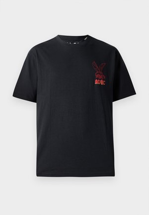 Melna kokvilnas T-krekls ar īsām piedurknēm, apaļu kaklu un sarkanu grafisko logotipu ar zaķi un tekstu "AC/DC" uz krūtīm.