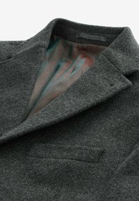 Blazer de lana gris con cuello con muesca, bolsillo frontal y forro interior con estampado en tonos de azul petróleo y coral. Textura suave.