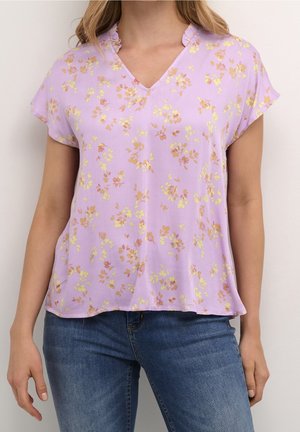 Lilla bluse med korte ærmer, V-hals og flæset krave. Har små gule og pink blomster mønstre. Letvægtsstof.