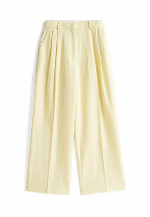 Fuinne gele wijde broek met voorplooien, twee zijzakken en een aangesloten taille. Gemaakt van een lichte stof.