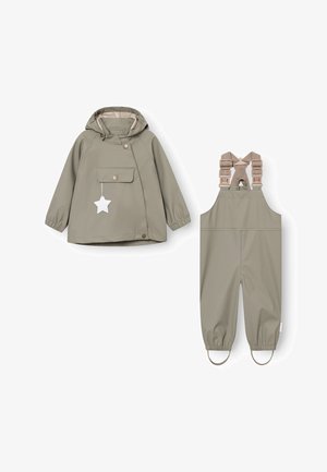 Ensemble de veste de pluie et de salopette en vert olive. La veste possède une poche sur le devant, des boutons-pression et une capuche avec cordon de serrage. La salopette a des bretelles réglables.