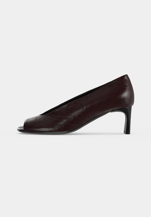 Vue latérale d'une chaussure à talons hauts en cuir marron foncé avec un bout pointu et un devant ouvert, présentée sur un fond clair.