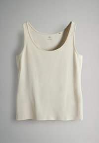 Maiou de culoarea crem, cu decolteu rotund și bretele late. Textură fină, cusături minimale și croială lejeră.