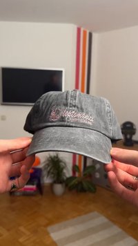 Hall halli pesapalli müts, mis on valmistatud kangast ning millel on roosade tikitud sõnadega "leptomanix". Disainis on kaardunud serv ja reguleeritav tagumine rihm.