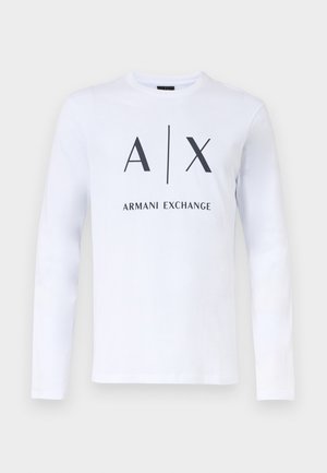 Bela majica z dolgimi rokavi s črnim napisom "A|X Armani Exchange" na sprednji strani, prikazana na enostavni svetli podlagi.