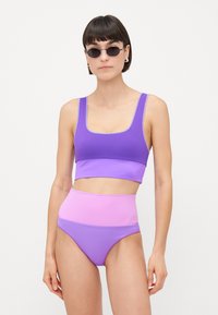 Μπικίνι σε δύο τόνους, μωβ και ροζ, με τοπ με τετράγωνη λαιμόκοψη και ψηλές bottoms, κατασκευασμένο από μαλακό συνθετικό υλικό.