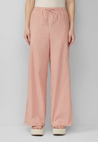 Pantalons légers à rayures de pêche douce et crème. Dotés d'une taille élastique avec un cordon de serrage, d'un design à jambe large et d'une texture lisse.