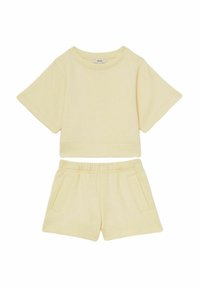 Gul bomulds to-dels sæt med en cropped T-shirt med brede ærmer og matchende shorts med for-lommer og elastisk talje.