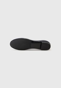 Pantofii negri cu toc înalt au o textură netedă, vârful rotund și o talpă solidă din cauciuc. Design simplu, fără modele sau hardware vizibil.