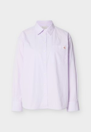 Hele lilla pika õlaga pikkade varrukatega puuvillane särk, millel on nööbitav krae, esikotike ja väike CK logo rinnal.