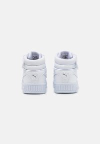 Witte hoge sneakers van glad synthetisch materiaal, met een gestructureerde zool en een prominent logo op de achterkant.