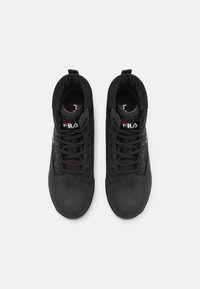 Baskets montantes noires avec un extérieur en cuir lisse, des lacets noirs robustes et un col rembourré. Logo Fila sur le côté. Doublure intérieure texturée.