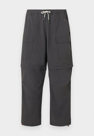 Pantalons cargo convertibles gris foncé avec taille à cordon, poches à rabat et jambes zippées qui se transforment en shorts.