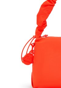 Lys orange taske med et tekstureret, polstret design. Har et knyttet håndtag og et rundt lynlåstræk i form af en monkey som et bemærkelsesværdigt accent.