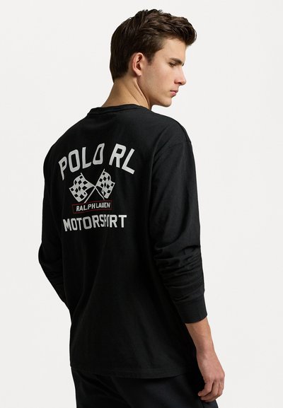 Must musta särk pikad varrukad musta värvi valgete tähtedega "POLO RL MOTORSPORT" ja ristatud ruudulised lipud seljal.