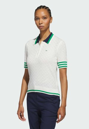 Polo shirt blanc avec un motif texturé, col marine et manches à rayures vertes. Présente un logo vert sur la poitrine et un design ajusté.