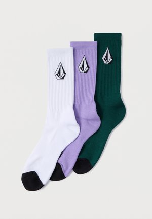 Three pairs of ribbed socks in white, lavender, and dark green, each featuring a black diamond logo on the side and contrasting toe colors.