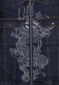 Tmavě modrá denimová bunda se středovým bílým vyšívaným designem draka, stříbrným zipem a dvěma předními kapsami se zapínáním na patenty.