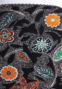Tissu noir avec un motif floral coloré, présentant des détails orange, rouge, turquoise et vert. Des lignes tourbillonnantes entourent des fleurs et des feuilles stylisées.