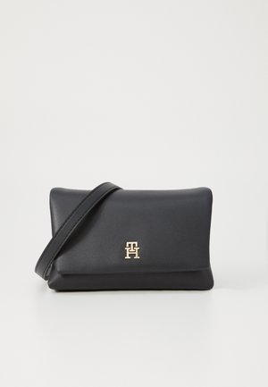 Svart lær clutch med et gull-logo aksent, rektangulær fasong, myk tekstur, og avtakbar strop for bruk som crossover.