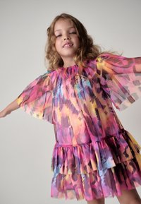 Farverig, transparent kjole med en flæset kant, prydet med et abstrakt akvarelmønster i nuancer af pink, lilla, gul og blå.