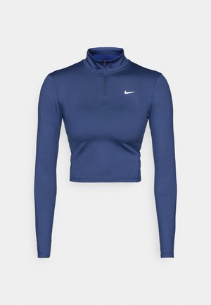 Haut court à manches longues, bleu marine, avec un col montant et une demi-fermeture éclair. Fabriqué en matériau lisse et extensible, avec un logo Nike blanc.