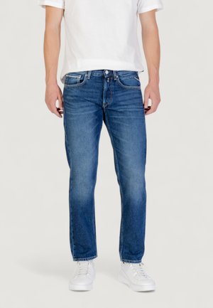 Jeans in denim azzurro chiaro con vestibilità dritta, design a cinque tasche e leggere sfumature. Abbinati a una t-shirt bianca e sneakers bianche.