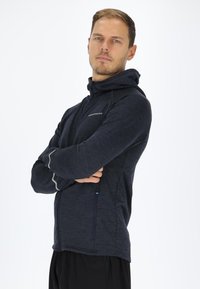 Navy blue zip-up hoodie with a textured finish, a hood, and contrasting light gray accents. Features side zippered pockets.