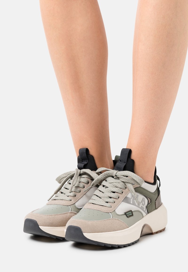 Baskets légères en nuances de vert olive et beige, présentant un mélange de suède et de mesh, avec des lacets ronds et un marquage audacieux sur le côté.