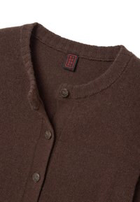 Bruine wollen cardigan met een ronde hals, voorzien van twee knopen en ribgebreide randen. Label bevestigd aan de halslijn.