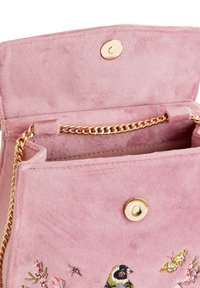 Bolso de suede rosa con cierre de botón dorado y correa de cadena. Presenta aves y mariposas bordadas en una superficie texturizada. Bolsillo interior visible.