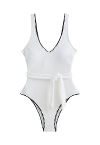 Costume da bagno intero bianco con scollatura a V profonda, bordo nero a onde e una cintura in tessuto annodata in vita. Tessuto morbido, forma aderente.